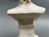 a statue of a woman sitting on top of a bust