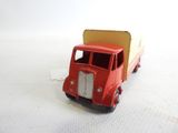 a red toy truck that is on a white surface