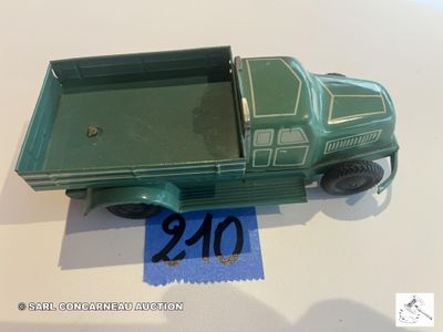 un petit camion vert en plastique posé sur une table