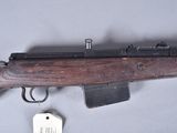an old wooden rifle with a key and a tag on a table
