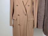 pair of men ' s coats on a mannequin stand on a white background
