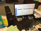 un ordinateur de bureau posé sur un bureau, à côté d'une calculatrice