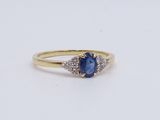 a yellow gold ring with a blue sapphire and diamonds