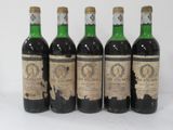 four bottles of wine are lined up on a white surface