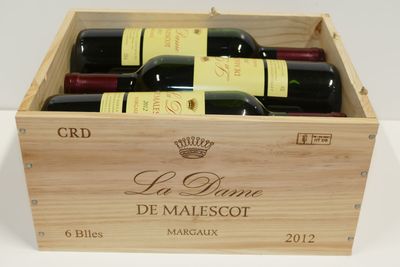 bouteilles de vin dans un coffret en bois sur une surface blanche