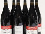 six bottles of red wine are lined up on a white surface