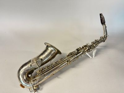 un saxophone plaqué argent posé sur une surface blanche