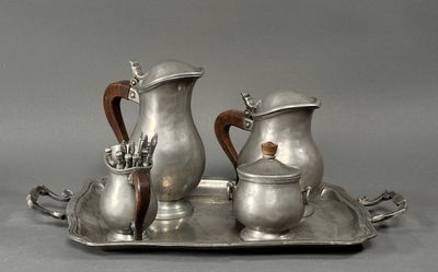 a silver tray with two silver pitchers and a cup on it