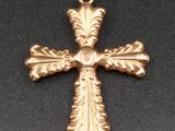 un pendentif en forme de croix dorée sur fond noir