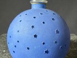 a blue bottle with stars on it sitting on a rock
