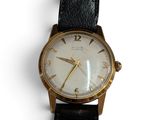 une image d'un gros plan d'une montre-bracelet sur une surface blanche