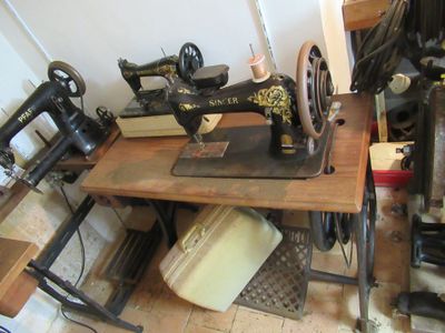 plusieurs vieilles machines à coudre posées sur une table dans une pièce