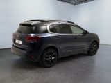 the rear end of a dark colored suv parked in a room