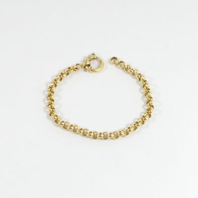 gros plan d'un bracelet en or sur fond blanc