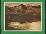 une vieille photo d'un pont enjambant une rivière, avec un bâtiment en arrière-plan