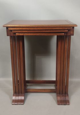 un ensemble de trois tables gigognes en bois sur fond gris