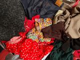 a pile of clothes that is sitting on a bed