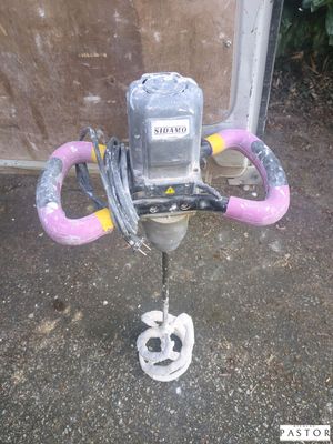 une photo d'une perceuse posée sur un support, avec une corde