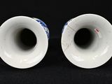pair of blue and white vases on a black background