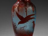 un vase avec un oiseau posé sur une table
