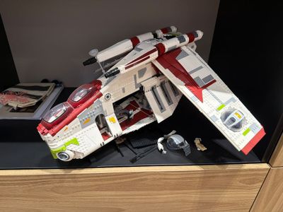 a lego starfighter sitting on a shelf next to a watch