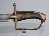 a close up of a sword with a wooden handle