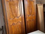 une grande armoire en bois dans le coin d'une pièce