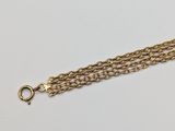 a close up of a gold chain bracelet on a white surface