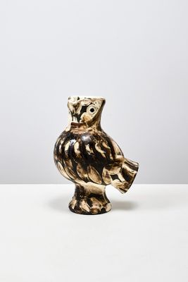 une figurine de chouette posée sur une table blanche