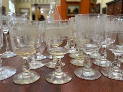many wine glasses sitting on a table with a bottle of wine in the background