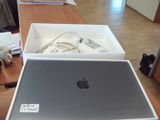un ordinateur portable Apple posé sur une table, dans une boîte