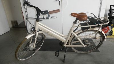 a white bicycle parked in a garage next to a white door