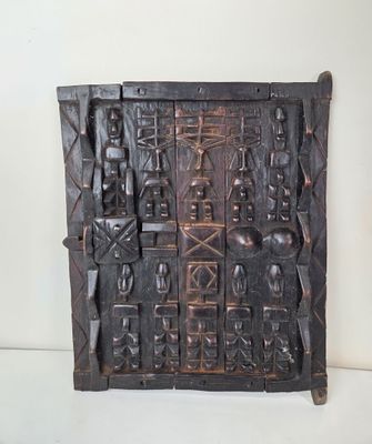 une plaque en bois comportant des sculptures sur un fond blanc