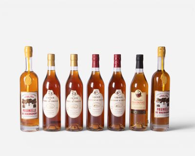six bottles of wine are lined up in a row on a white surface