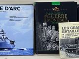 several books on a shelf with a blue boat in the background