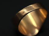 a close up of a gold ring on a black background