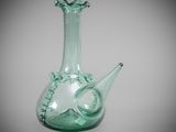 a green glass vase that is sitting on a table
