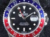 une photo d'une montre Rolex avec une lunette rouge et bleue