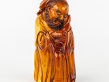 une image représentant une figurine sculptée d'un homme barbu