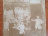 an old photo of a group of men standing in front of a store