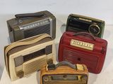 Trois radios à l'ancienne sont posées sur une surface blanche