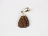 a close up of a wooden pendant on a white surface