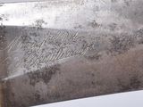 a silver knife with writing on it sitting on a table