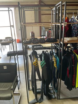 a room with a rack of clothes and a chair