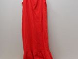 a red dress hanging on a hanger next to a pile of clothes