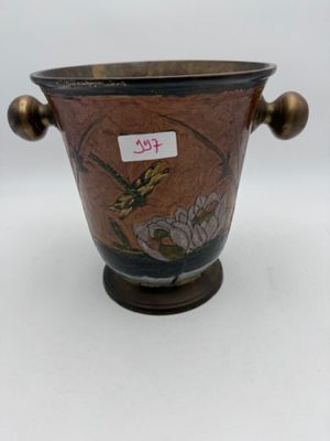 a brown vase with a bird on it on a table