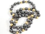 black and gold beaded necklace on a white background