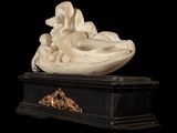 marble sculpture of a woman laying on a shell on a marble base