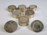 several stacks of coins sitting on top of each other on a white surface