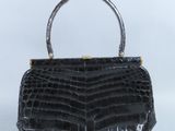 un sac à main en cuir de crocodile noir muni d'une poignée en métal